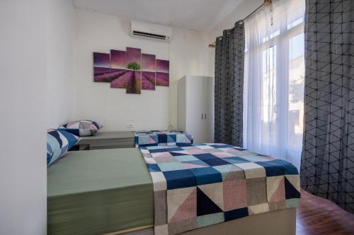 a bedroom with two beds and a painting on the wall at Apartment Lavanda Neum in Neum