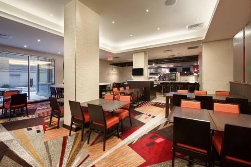 a restaurant with tables and chairs and a kitchen at Courtyard by Marriott Times Square West in New York
