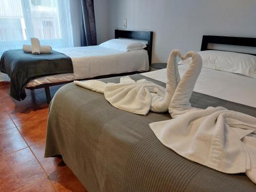 a hotel room with two beds with towels on them at Hotel Mirtil in Pas de la Casa