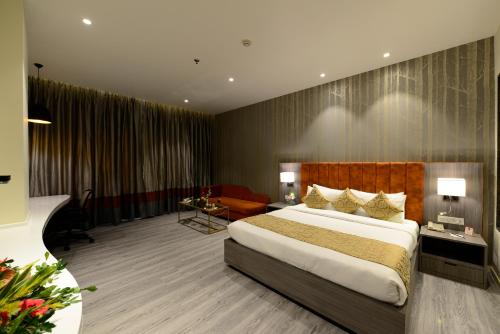 a hotel room with a large bed and a couch at Hotel Deep Clarks Inn Lucknow in Lucknow