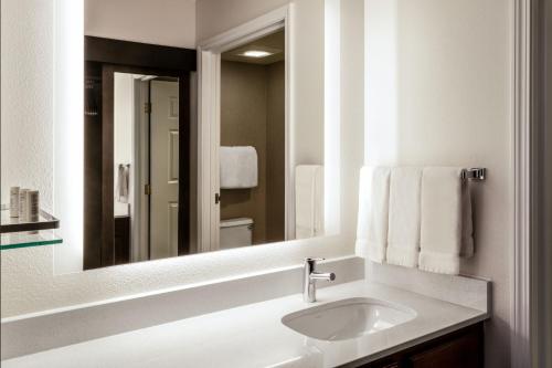 Baño blanco con lavabo y espejo en Residence Inn by Marriott Boulder Broomfield en Louisville