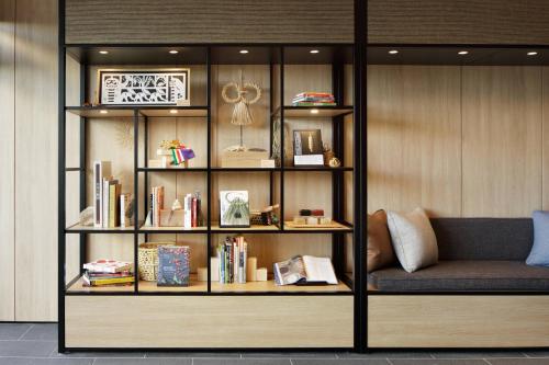 a book shelf with books and a couch in a room at Fairfield by Marriott Kyoto Kyotamba in Nantan city