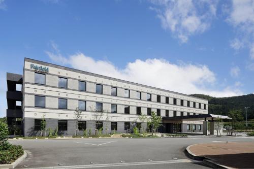 a large white building with a parking lot in front of it at Fairfield by Marriott Kyoto Kyotamba in Nantan city