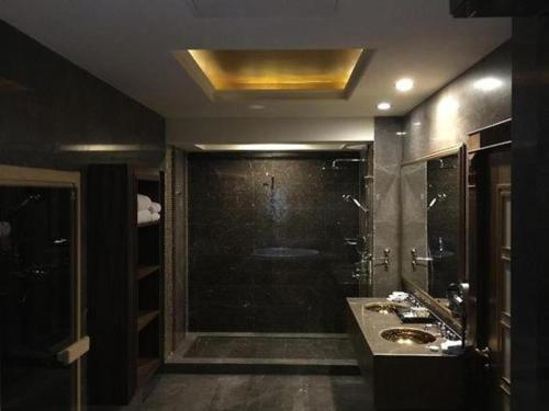ein großes Bad mit einer Dusche und einem Waschbecken in der Unterkunft Crixus Duhok in Dohuk