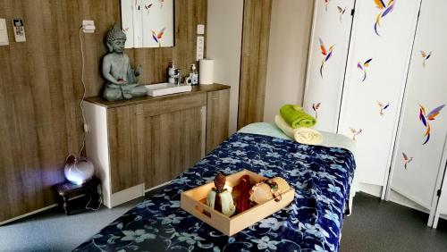 a bedroom with a bed with a box of dolls on it at Bien être en 5 étoiles au cœur du sud Ardèche, vignobles et rivières in Lagorce