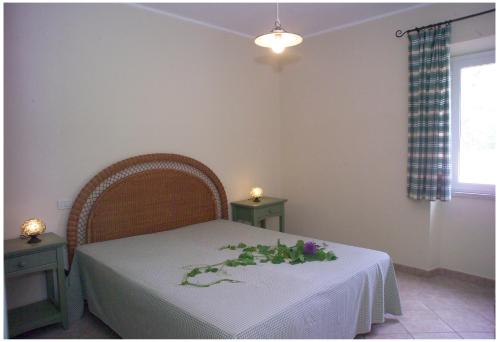 a bedroom with a table with a white table cloth and flowers on it at Appartamenti Tallinucci in Lacona