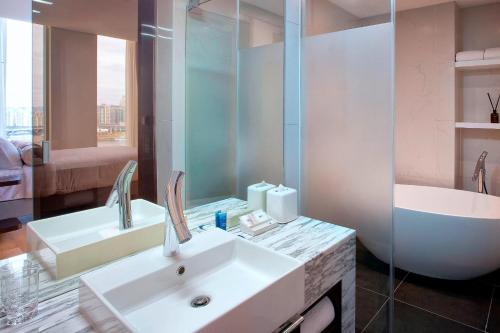首爾的住宿－首爾江南雅樂軒酒店，浴室配有水槽、淋浴和浴缸。