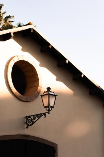 a light on the side of a building with a window at Sella&Mosca Casa Villamarina in Alghero