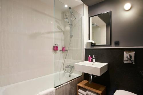 a bathroom with a shower and a sink and a toilet at Moxy Paris Bastille in Paris