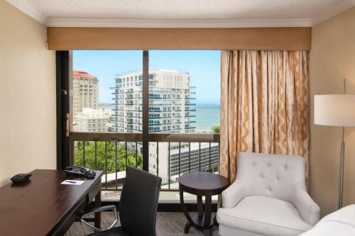 ein Hotelzimmer mit einem Schreibtisch und einem großen Fenster in der Unterkunft Sheraton Santo Domingo in Santo Domingo