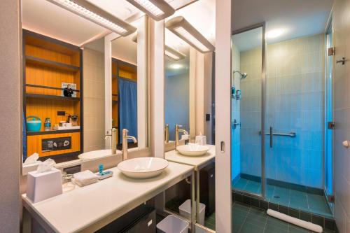 a bathroom with two sinks and a shower at Aloft Portland Airport Hotel at Cascade Station in Portland