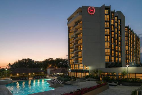 a hotel with a clock tower next to a pool at Sheraton Santo Domingo in Santo Domingo