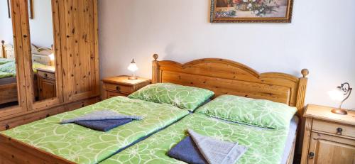 ein Schlafzimmer mit einem Bett mit einer grünen Bettdecke in der Unterkunft Chalupa na Koskách in Třeboň