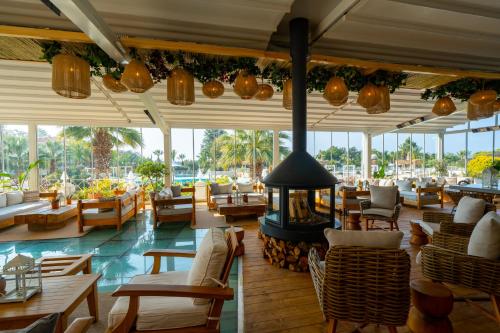 a restaurant with a fireplace and tables and chairs at Mark Warner Phokaia Beach Resort in Foca
