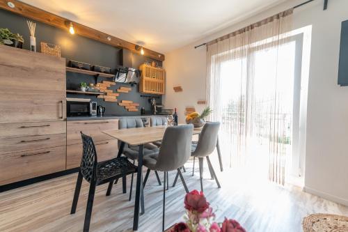 Il comprend une cuisine et une salle à manger avec une table et des chaises en bois. dans l'établissement Sea View Apartment Ana, à Podstrana