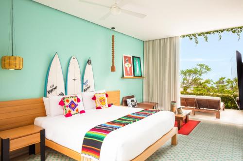a bedroom with a bed with surfboards on the wall at W Punta de Mita in Punta Mita