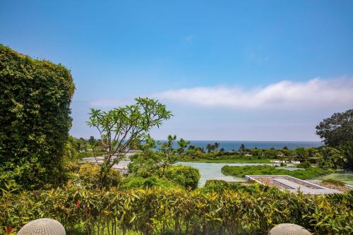 a view of a garden with the ocean in the background at W Punta de Mita in Punta Mita