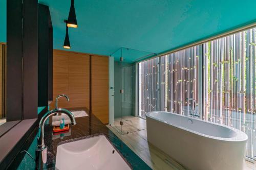 a bathroom with a tub and a large window at W Punta de Mita in Punta Mita
