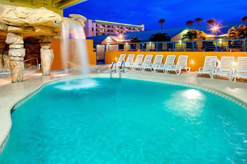 a swimming pool at a resort at night at Four Points by Sheraton Cocoa Beach in Cocoa Beach