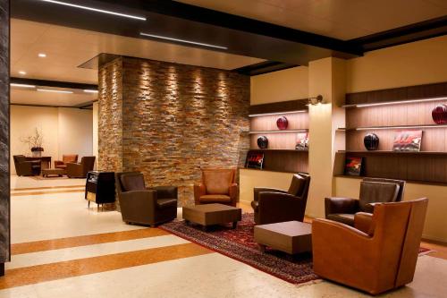 a waiting room with chairs and a brick wall at Four Points by Sheraton Padova in Padova