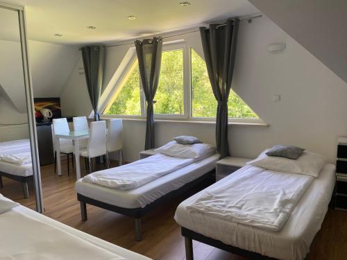 a room with two beds and a table and a window at Domki u Ewy in Stronie Śląskie