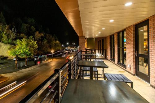 a restaurant balcony with tables and a street at night at Four Points by Sheraton Deadwood in Deadwood