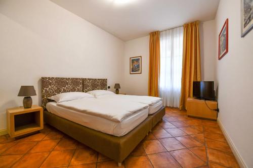 a bedroom with a bed and a television in it at Aquazzurra Resort & Aparthotel in Cannobio