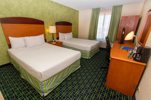 a hotel room with two beds and a desk at Wyndham Garden Monterrey Aeropuerto in Monterrey