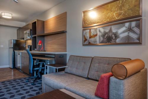 a living room with a couch and a kitchen at TownePlace Suites by Marriott Indianapolis Airport in Indianapolis