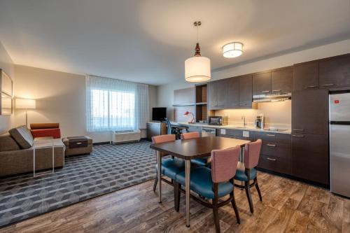 a kitchen and living room with a table and chairs at TownePlace Suites by Marriott Indianapolis Airport in Indianapolis