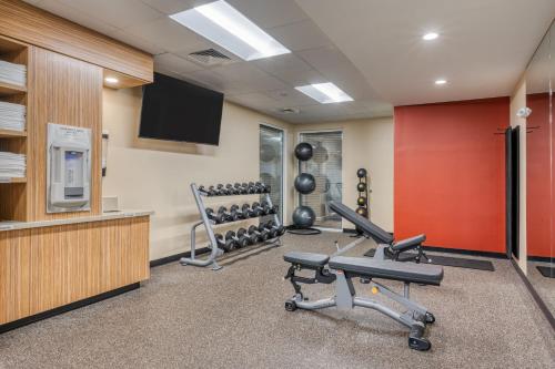 a fitness room with two chairs and a television at TownePlace Suites by Marriott Indianapolis Airport in Indianapolis