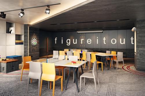 a restaurant with tables and chairs and a sign that reads etiquette at Moxy Xi'an Beilin in Xi'an
