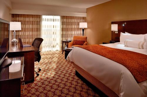 a hotel room with a bed and a desk with a laptop at Marriott Louisville East in Louisville