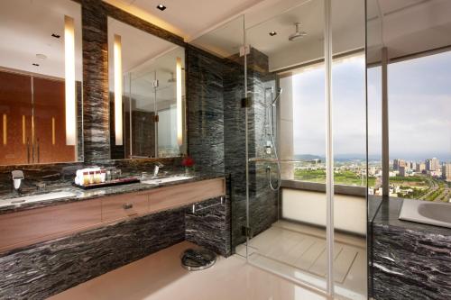 a bathroom with a glass shower and a sink at Sheraton Hsinchu Hotel in Zhubei