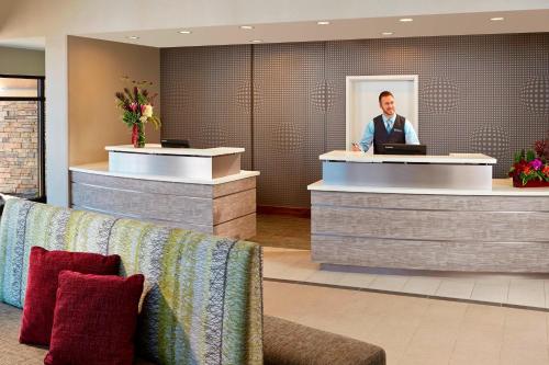 a man standing at a counter in a hotel lobby at Residence Inn by Marriott Los Angeles Redondo Beach in Redondo Beach