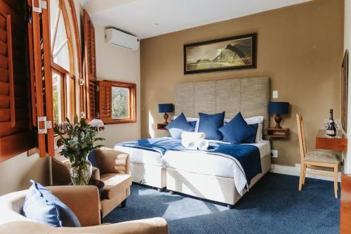 a bedroom with a large bed with blue pillows at Floreal House in Cape Town