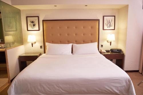 a large bed in a hotel room with two lamps at Sheraton Lima Historic Center in Lima