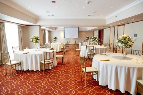 a conference room with tables and chairs and a screen at Sheraton Lima Historic Center in Lima