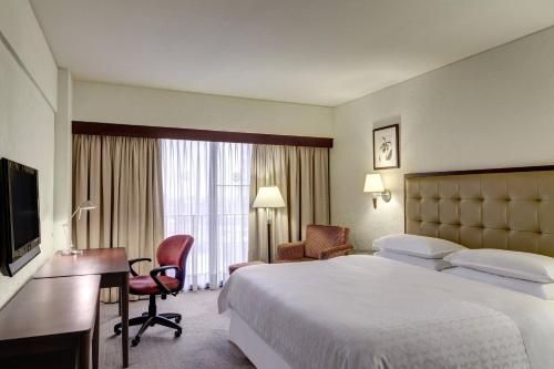 a hotel room with a bed and a desk and a television at Sheraton Lima Historic Center in Lima