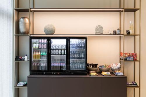 a drink cooler in a room with shelves at AC Hotel by Marriott Wuerzburg in Würzburg