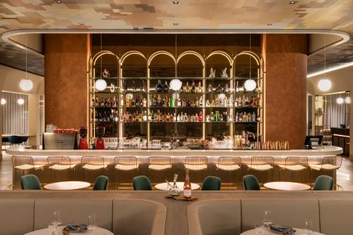 a restaurant with a bar with tables and chairs at AC Hotel by Marriott Wuerzburg in Würzburg