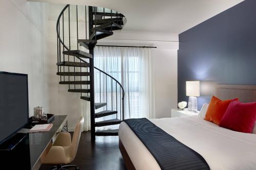 a bedroom with a spiral staircase next to a bed at Hotel Colonnade Coral Gables, Autograph Collection in Miami