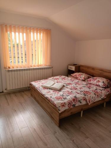 - une chambre dotée d'un grand lit avec un couvre-lit floral dans l'établissement Casa Edental, à Orăştie