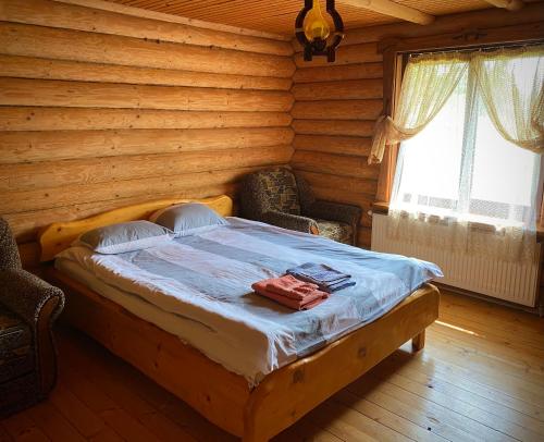 a bedroom with a bed in a log cabin at Гостинний двір in Oryavchyk