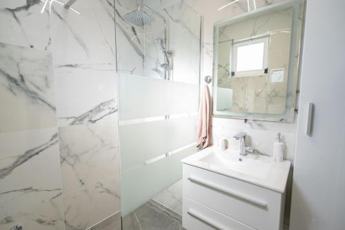 a white bathroom with a sink and a mirror at Kuca za odmor Sliskovic 