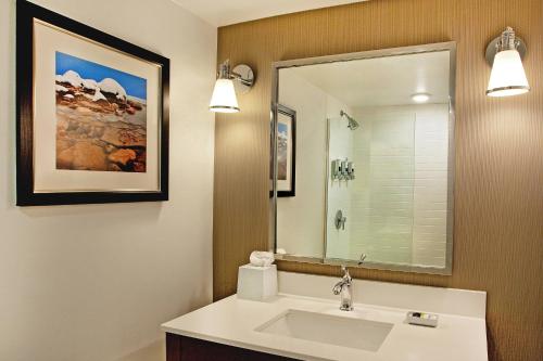 a bathroom with a sink and a mirror at Four Points By Sheraton - Saginaw in Saginaw