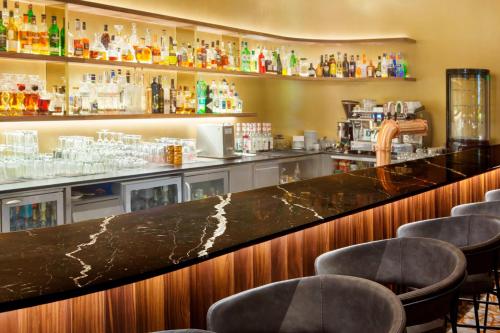 a bar in a restaurant with a counter and chairs at The Westin Warsaw in Warsaw