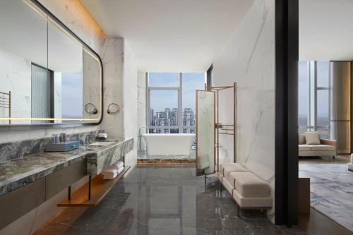 ein Badezimmer mit einer Badewanne, einem Waschbecken und einer Couch in der Unterkunft Courtyard by Marriott Wenzhou Yueqing in Yueqing