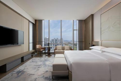a hotel room with two beds and a flat screen tv at Courtyard by Marriott Wenzhou Yueqing in Yueqing