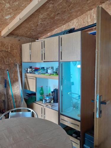 eine Küche mit einem Tisch und einem Glasschrank in der Unterkunft Kapitalac in Banatska Palanka